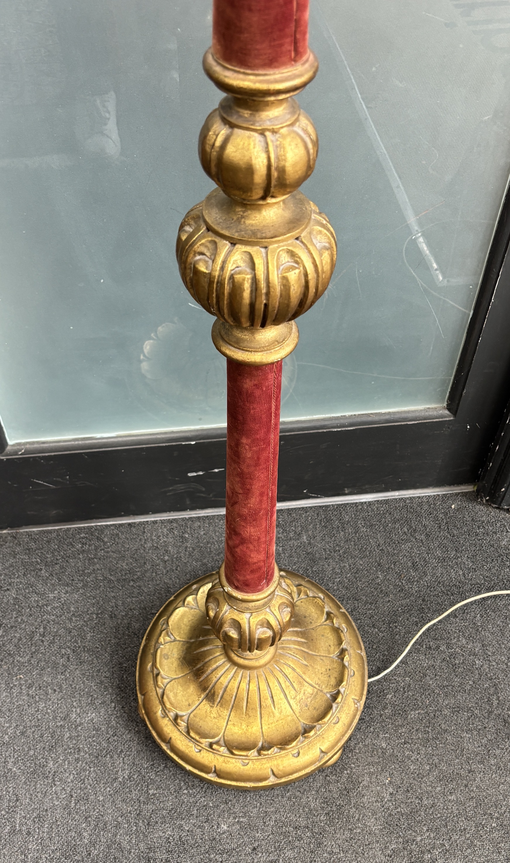 A gilt standard lamp with part fabric covered column